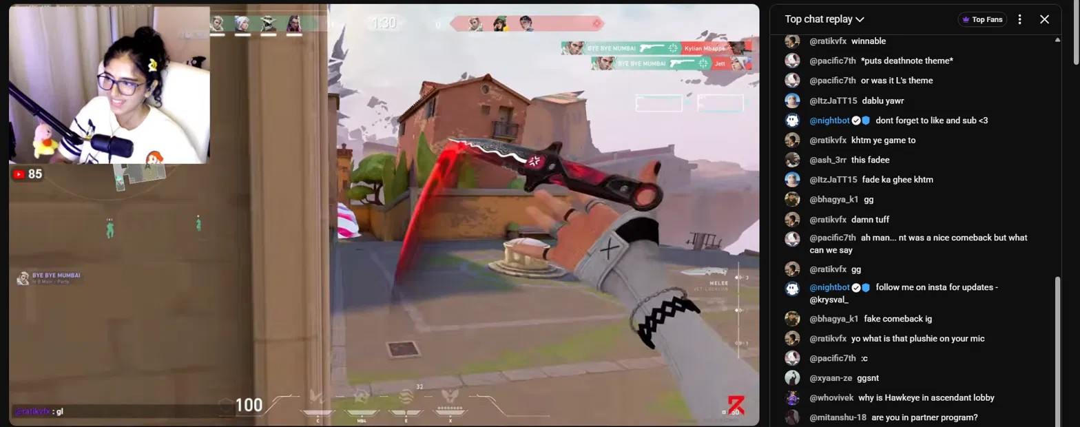A live stream in progress: facecam top left, Valorant gameplay centre, and live chat scrolling on the right